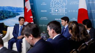 Prime Minister Justin Trudeau sits and talks with PM Shinzo Abe.