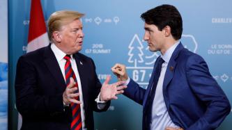 Prime Minister Trudeau stands and talks with President Donald Trump.