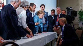 La chancelière Merkel parle au président Trump devant les dirigants du G7.