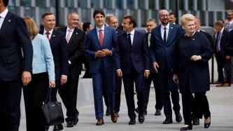 Le PM Trudeau marche à l'extérieur avec d'autres dirigeants.