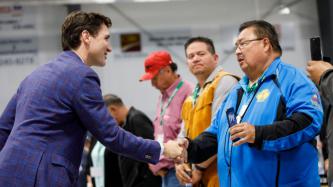 PM Trudeau shakes hands with a man 