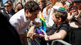 PM Trudeau shake hands with a young boy in the crowd