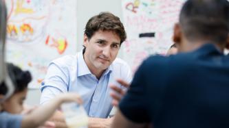 PM Trudeau listens to a man speak