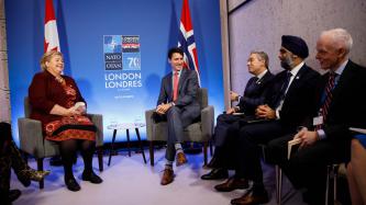 PM Justin Trudeau sits laughing with the PM of Norway, Ema Solberg