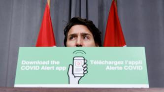 Le PM Trudeau derrière une affiche sur l’application Alerte COVID