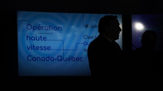 La silhouette du PM Legault alors qu'il se tient devant un écran