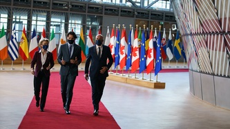 PM Trudeau, President Michel and President von der Leyen walk on a red carpet