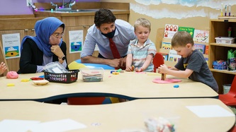 PM Trudeau watches children play at a table