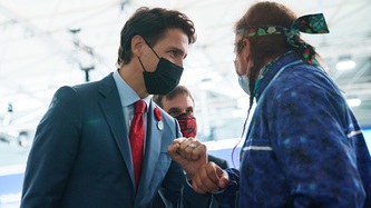 Prime Minister Justin Trudeau exchanges an elbow bump with a man
