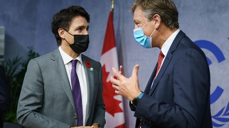 Prime Minister Justin Trudeau looks at a man motioning with their hands