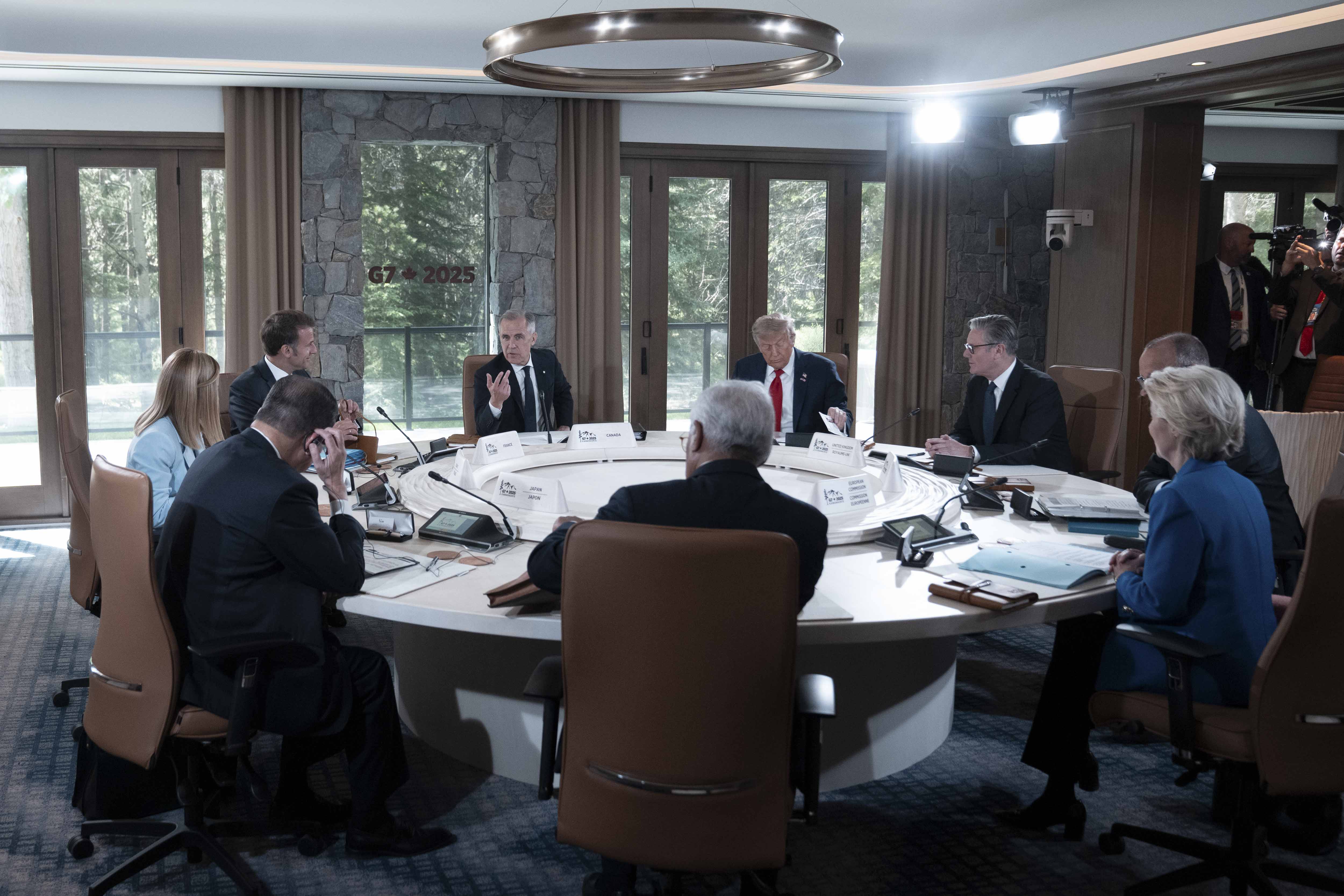Prime Minister Carney is seated at a round table and speaking with G7 and world leaders during a G7 working session.