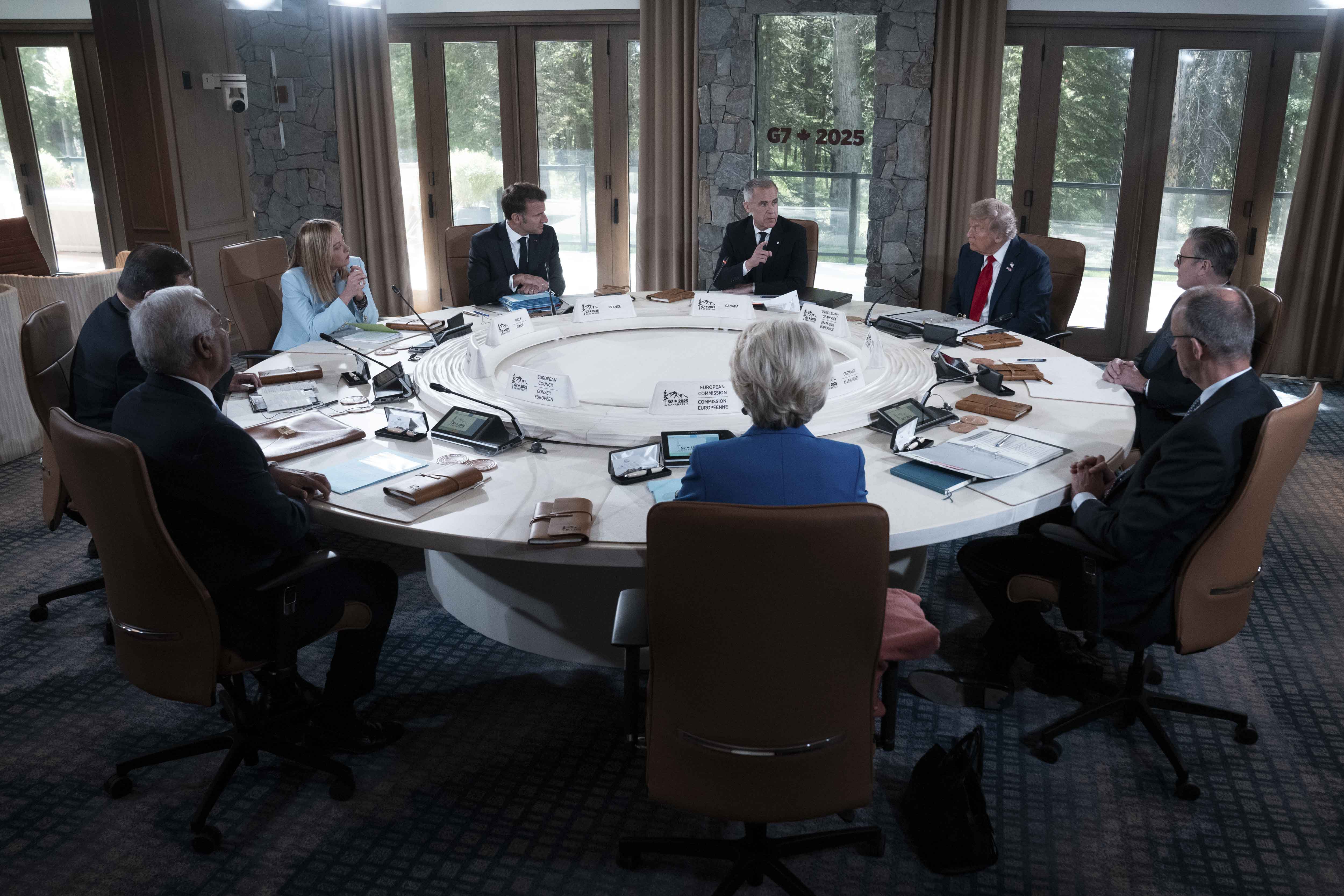 Prime Minister Carney is seated at a round table and speaking with G7 and world leaders during a G7 working session.