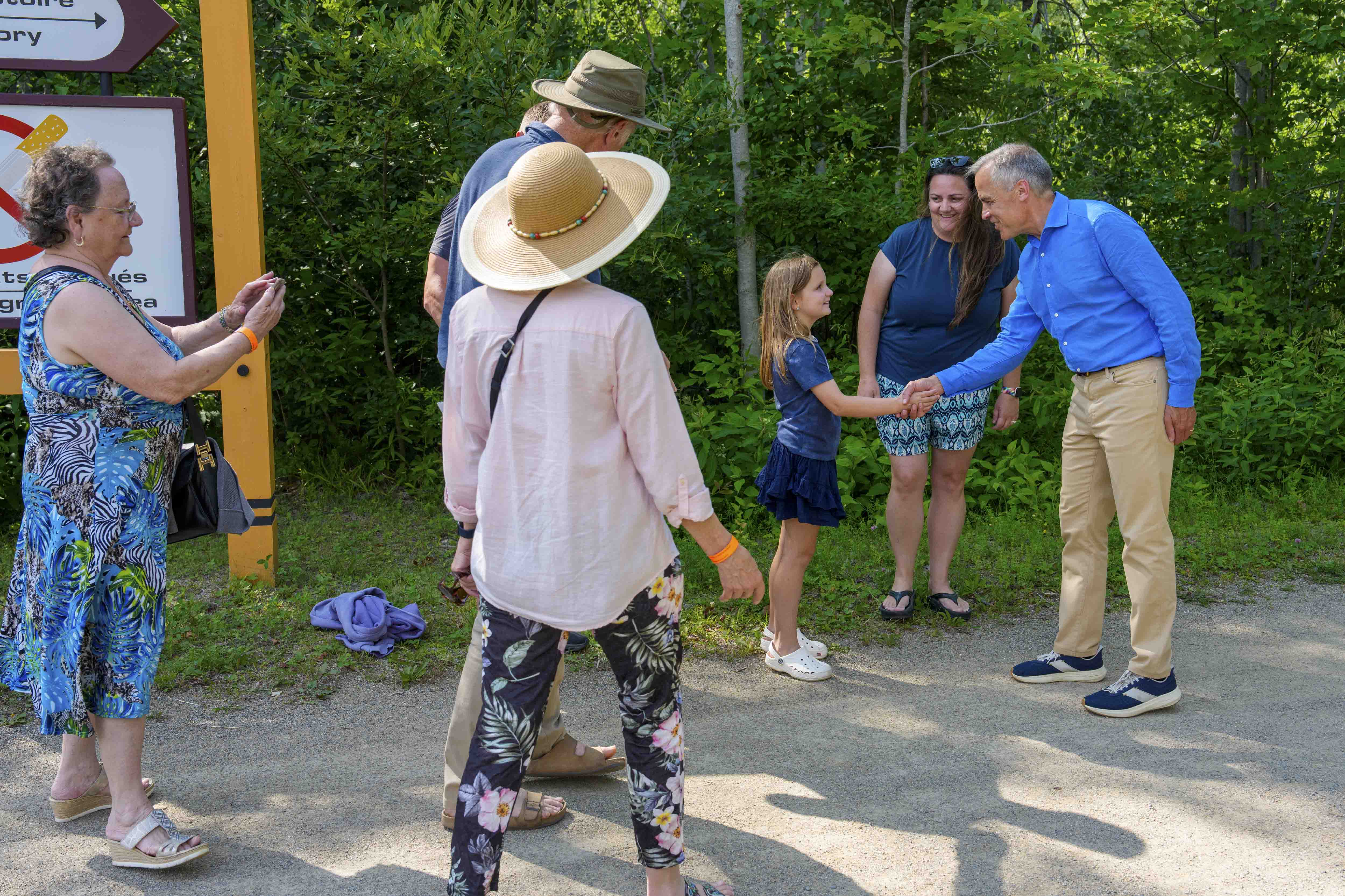 Prime Minister Mark Carney greets a family during a tour of the Village Historique Acadien.