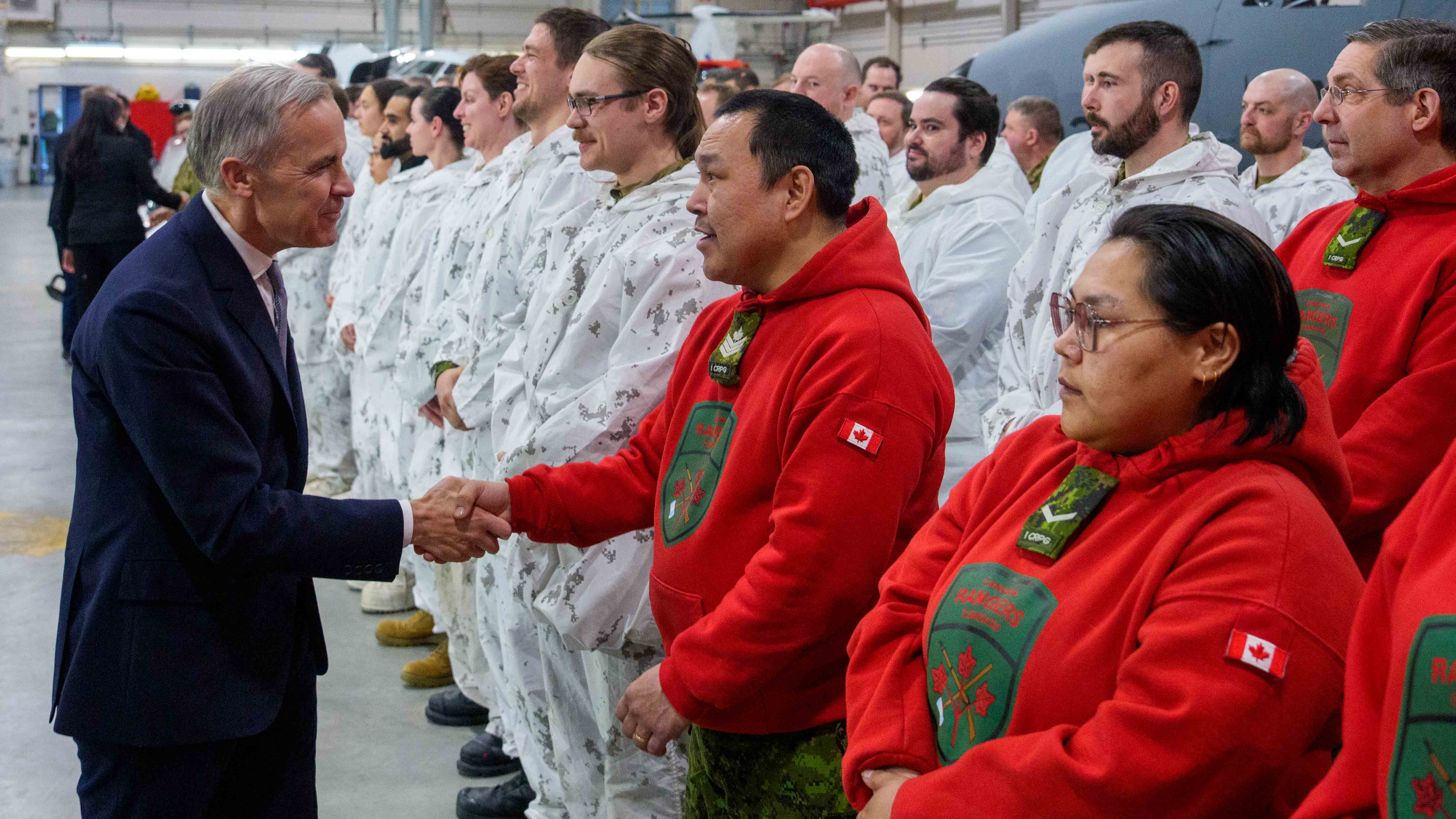 Prime Minister Mark Carney meets with members of the Canadian Armed Forces and shakes hands with a Canadian Ranger.