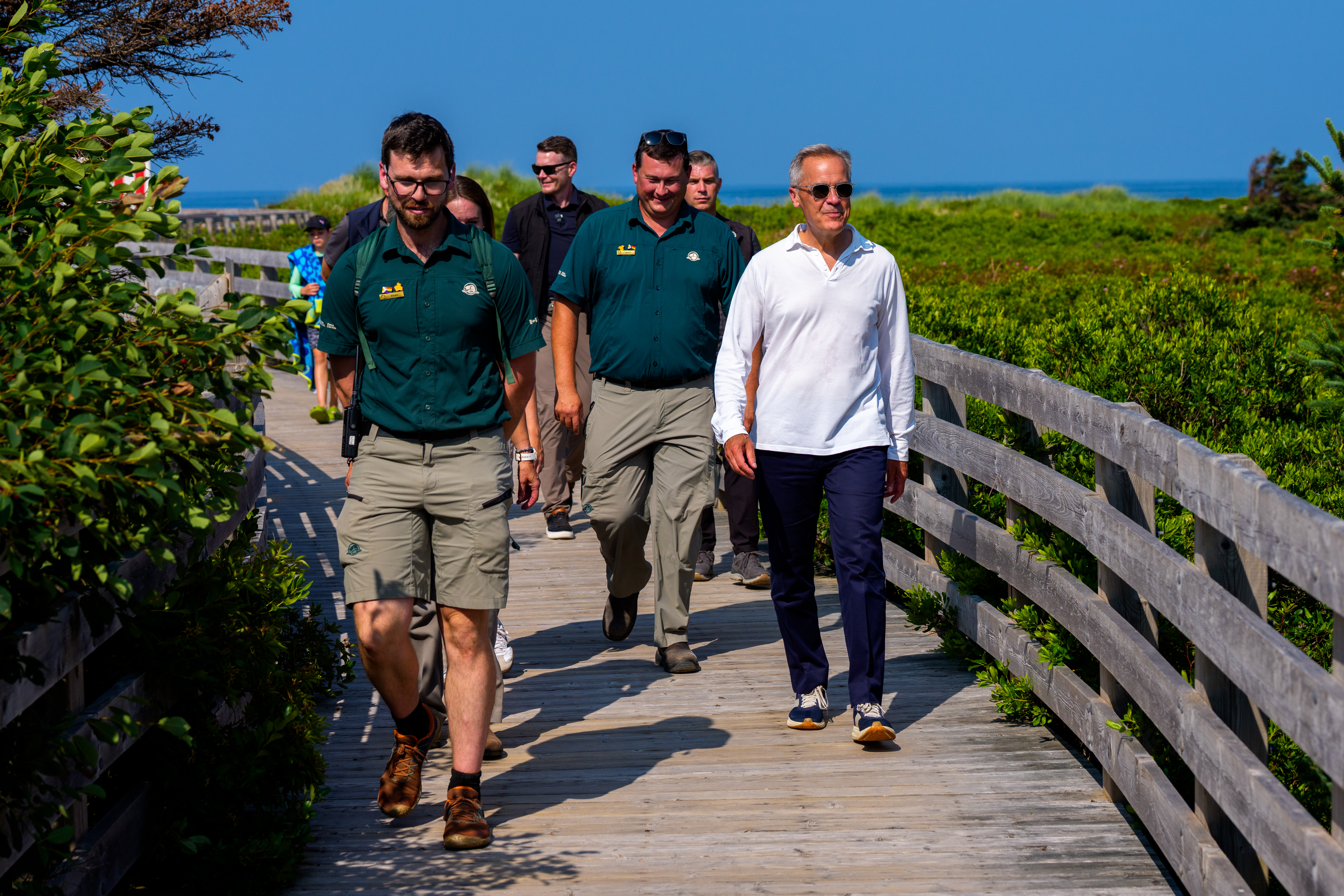 Prime Minister Mark Carney visits Prince Edward Island National Park and walks with Parks Canada employees and others.