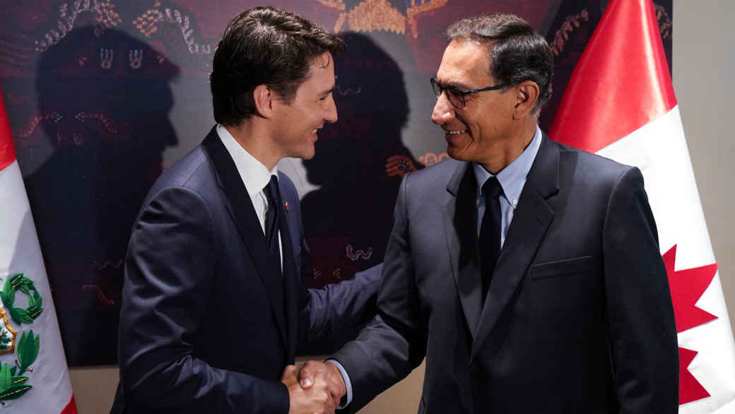 Prime Minister Justin Trudeau shakes hands with President of Peru Martin Vizcarra with Peruvian and Canadian flags in the background