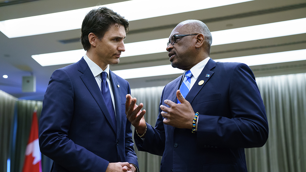 No title Prime Minister Justin Trudeau speaks with Prime Minister of The Bahamas Hubert Minnis in a conference room.
