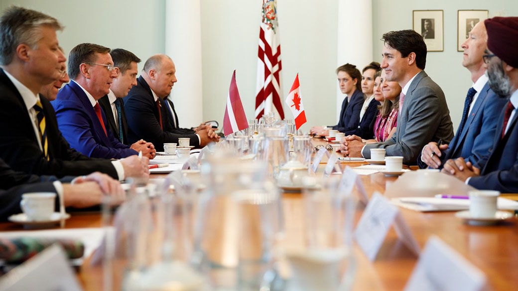 No title PM Trudeau sits in a meeting with the Prime Minister of Latvia.