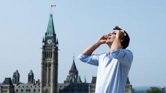 Photo number 1 from the photo gallery Prime Minister Justin Trudeau watches the solar eclipse from his office rooftop