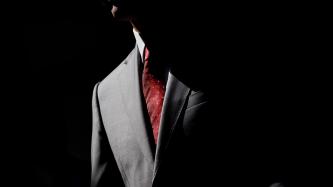 Prime Minister Justin Trudeau is shown from the waist up with his face covered by a shadow