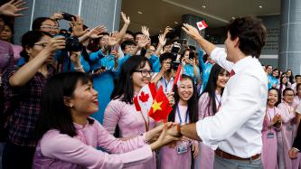 Prime Minister Justin Trudeau greets and waves to group of female students at Ton Duc Thang University