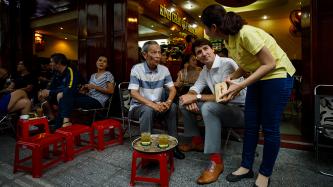 Prime Minister Justin Trudeau and Nguyen Cong Hiep of the Canadian Consulate have their order taken by a server at a coffee shop