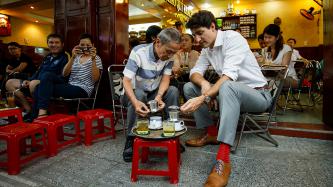 Prime Minister Justin Trudeau and Nguyen Cong Hiep sit and prepare their coffee