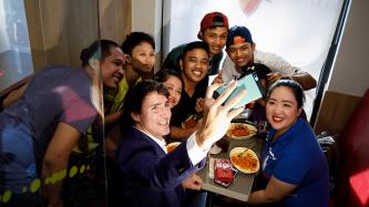Le premier ministre Justin Trudeau pose pour un autoportrait avec un groupe de clients attablés dans le compartiment d’un restaurant-minute Jollibee
