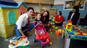 Prime Minister Justin Trudeau poses for a photograph with a young girl and members of the YWCA Crabtree Corner Community Resource Centre