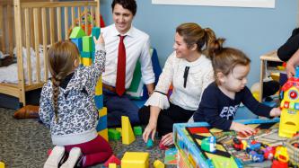 Prime Minister Justin Trudeau and Sophie Grégoire Trudeau play building blocks with a young girl 