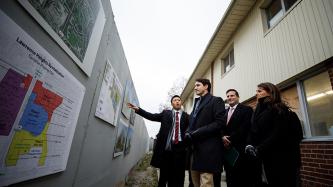Prime Minister Justin Trudeau is shown photos of the Lawrence Heights Revitilization Project at the building site