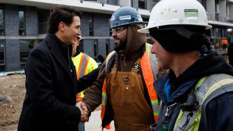 Prime Minister Justin Trudeau shakes hands with a construction worker