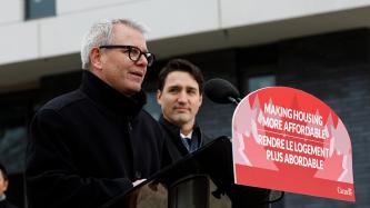 MP Adam Vaughan delivers remarks at the building site while Prime Minister Justin Trudeau looks on