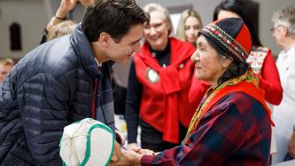 Prime Minister Trudeau holds hands with an attendee
