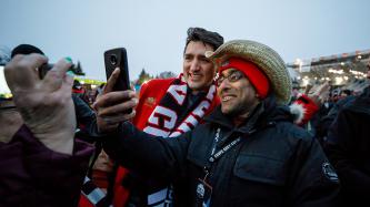 Prime Minister Justin Trudeau poses for selfie photograph with a fan before the Grey Cup