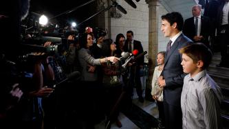 Prime Minister Justin Trudeau speaks to the media while his daughter Ella-Grace and son Xavier look on