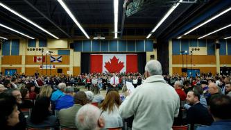 A crowd member asks Prime Minister Justin Trudeau a question
