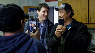 Prime Minister Justin Trudeau takes pictures with members of the Council of Pikangikum First Nation.