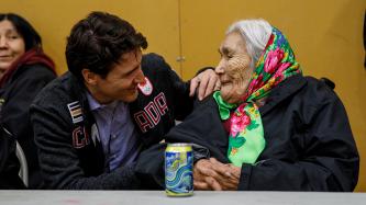 Prime Minister Justin Trudeau talks with an elderly woman of the Pikangikum community at the Community Centre.