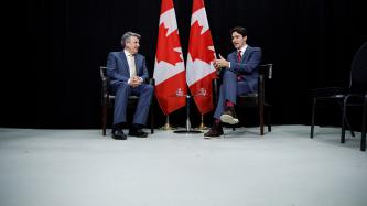 Prime Minister Justin Trudeau meets with Ben van Beurden, Global CEO of Royal Dutch Shell beside two Canadian flags.