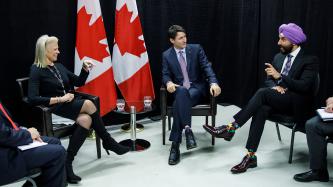 Prime Minister Justin Trudeau and Minister Navdeep Singh Bains meet with Ginny Rometty, President and CEO of IBM beside two Canadian flags.