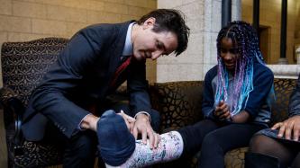 Prime Minister Justin Trudeau signs the leg cast of Sheriauna Honeyghan.