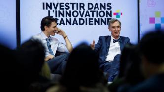 Bill Nye speaks to the audience while Prime Minister Justin Trudeau looks on during an armchair discussion at the University of Ottawa