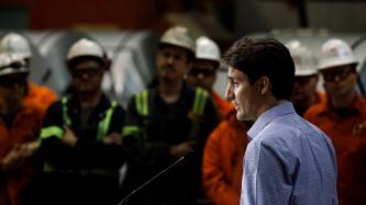 Prime Minister Justin Trudeau addresses workers at the ArcelorMittal Dofasco plant from a podium