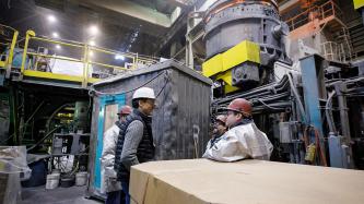 Prime Minister Justin Trudeau speaks with three Algoma steel workers inside the Direct Strip Production Complex