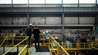 Prime Minister Justin Trudeau and an Algoma steel worker observe the facility from a footbridge above