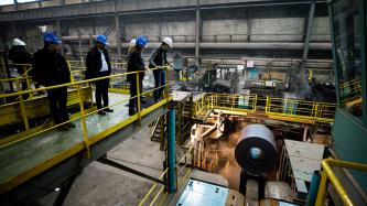 Prime Minister Justin Trudeau, MP Terry Sheehan and several Algoma steel workers observe the facility from a footbridge above