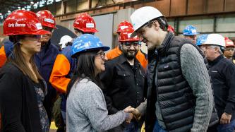 Prime Minister Justin Trudeau shakes hands with an Algoma steel worker at the Direct Strip Production Complex alongside MP Terry Sheehan and other steel workers