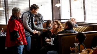 Prime Minister Justin Trudeau shakes hands with a customer at Muio's Restaurant while MP Terry Sheehan stands next to him.