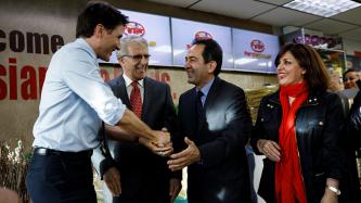 Prime Minister Justin Trudeau is greeted by customers at the Parsian Fine Foods grocery store.